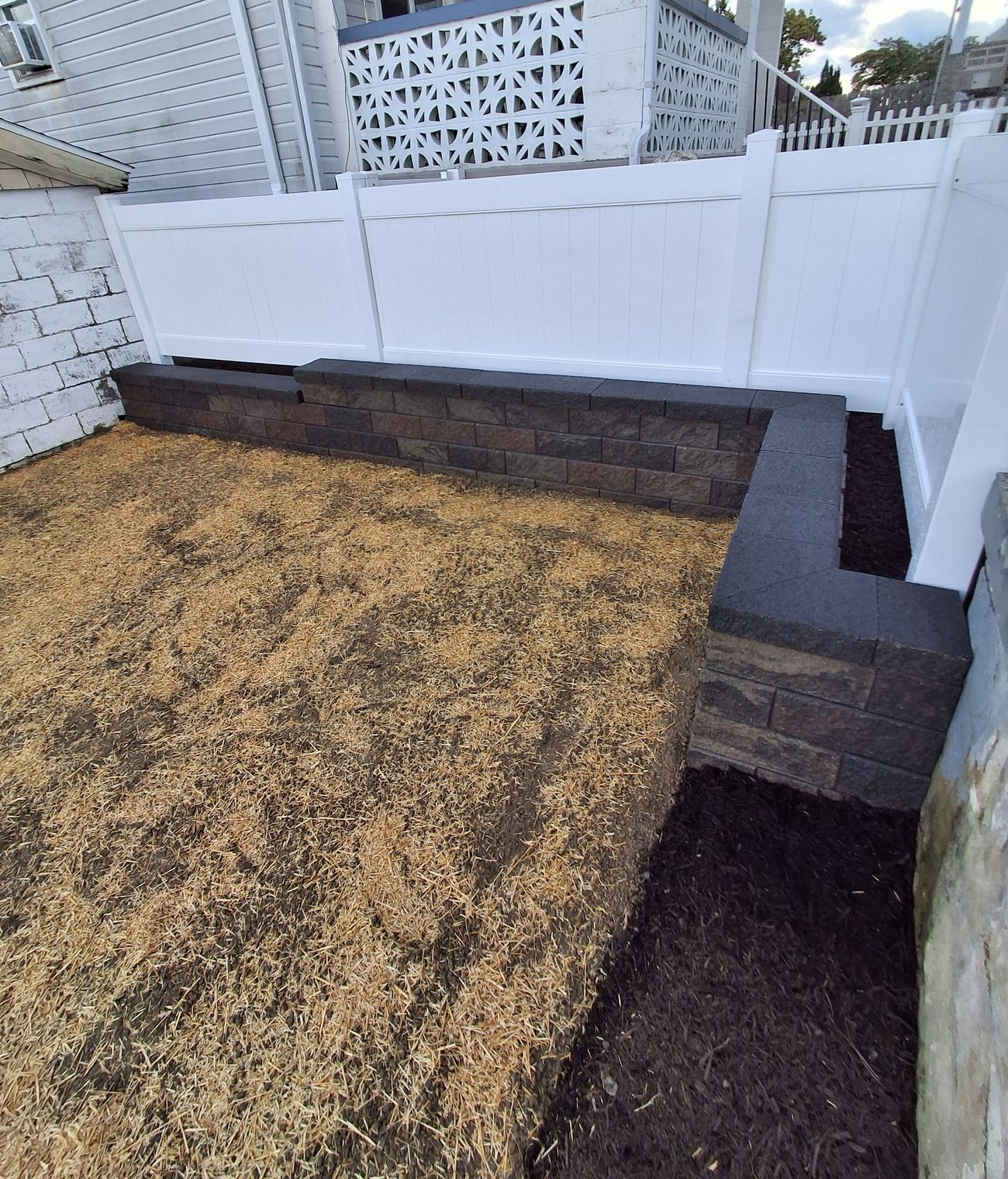 A block seat wall around a freshly seeded yard